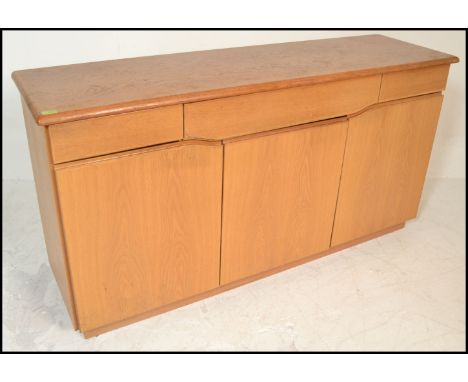 A Skovby 20th century light oak sideboard having a wide body with a series of blind fronted drawers and cupboards together wi