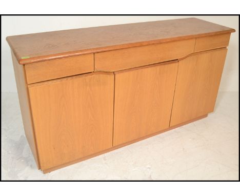 A Skovby 20th century light oak sideboard having a wide body with a series of blind fronted drawers and cupboards together wi