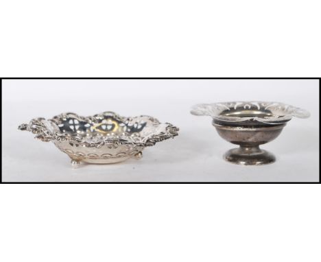 Two early 20th Century silver hallmarked trinket dishes to include a round dish being raised on a footed base with a crenelat