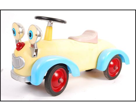 An unusual Triang style ride on push along pedal car type toy having moulded plastic details with chrome eye headlamps and fa