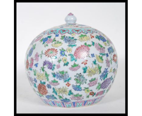 A polychrome enamel Chinese ginger jar of bulbous form, having floral decoration, geometric pattern borders and decorated lid