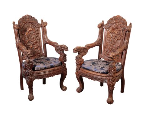 A PAIR OF CHINESE HARDWOOD THRONE CHAIRS, LATE QING, circa 1870 Extensivley carved with playful Buddhistic lions amidst bloss