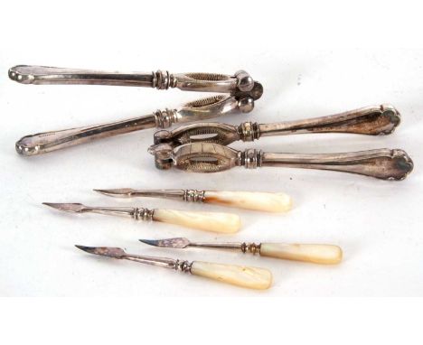 A  cased set two pairs of silver plated nut crackers together with four mother of pearl hand tools