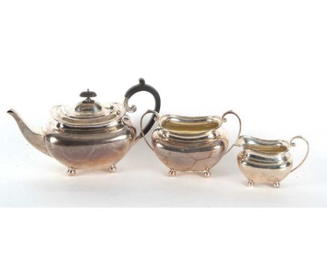 A George V silver three piece tea service comprising teapot, a twin handled sugar bowl and a milk jug, hallmarked for Sheffie