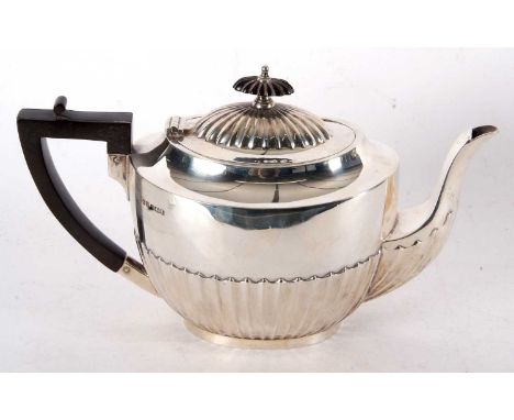 A George V silver teapot, part fluted decoration to hinged lid and body, ebonised finial and handle, hallmarked for Sheffield