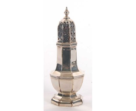 A George V silver caster of plain octagonal form, having a pull off lid with pierced geometric design, urn finial, hallmarked