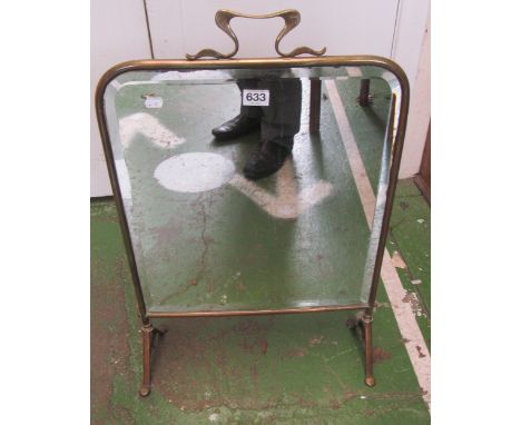 A mirrored brass fireguard