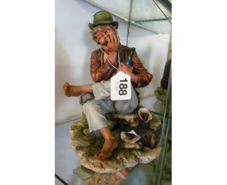 A Capodimonte figure man drinking and playing harmonica