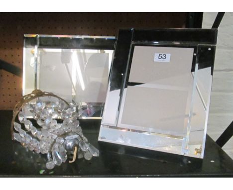 Two mirrored frames and a wall light