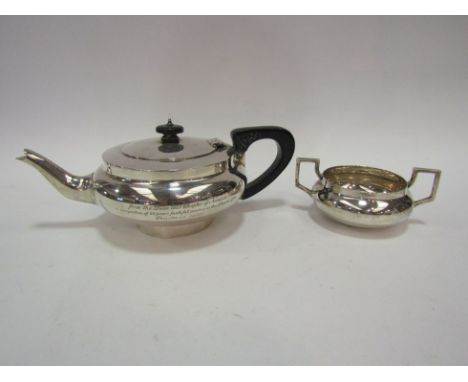 A silver two piece tea set with ebony knop and handle engraved inscription to front, London 1921, 563g