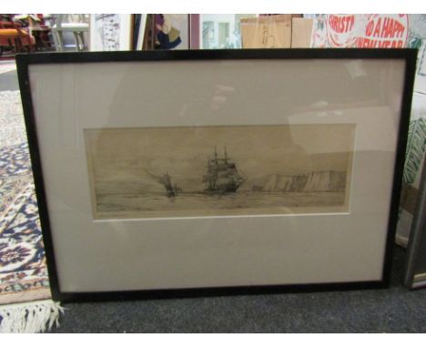 HAROLD WYLLIE (1880-1973) A signed etching depicting a tall ship and sailing boat, framed and glazed, 50.5cm x 35cm