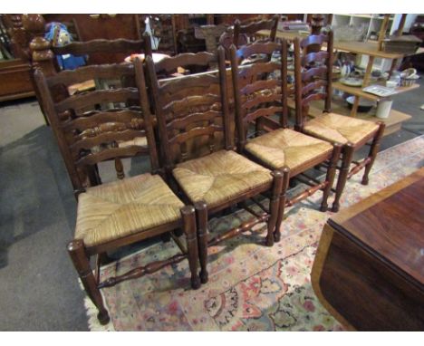A set of eight (6+2) oak ladder back dining chairs the rush seats over turned legs united by stretchers