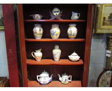 A collection of Quimper faience pottery items including jugs, brandy barrell on stand, armorial quaich, coffee pot etc