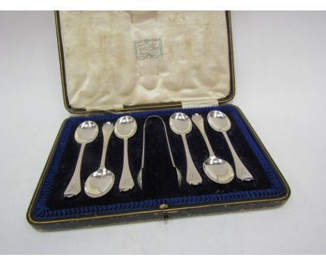 A set of six silver trefoil style teaspoons and sugar tongs with monogrammed handles, London 1901, cased, 105g  