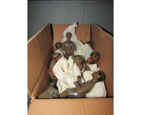 A box containing seven ceramic African figures