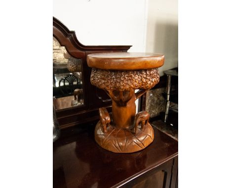 A MODERN PEDESTAL TABLE, HAVING CIRCULAR TREE TRUNK TOP OVER CARVED WALKING ELEPHANT RING 