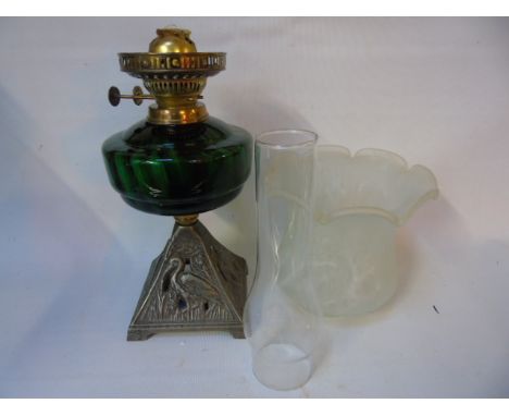 Green glass oil lamp with cast iron base and cloud glass shade
