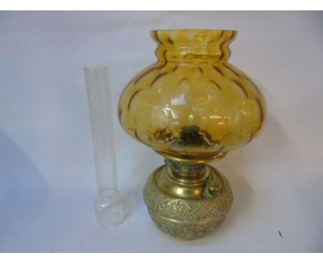 Vintage embossed brass oil lamp with amber glass shade