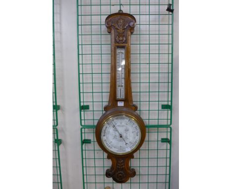 A carved oak aneroid barometer