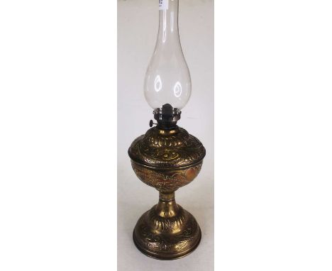 An Art Nouveau influenced embossed brass floral decorated oil lamp, with glass chimney, height 53.5cm