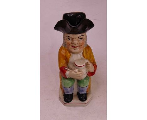 A Staffordshire style pottery Toby jug, in the form of a seated figure wearing a tricorn hat with stein and pipe, h.25cm