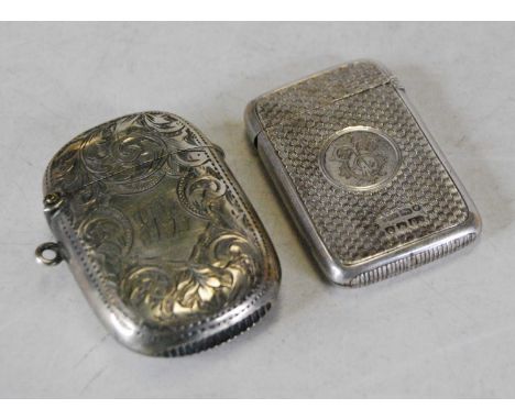An Edwardian silver vesta, of rounded rectangular form, having foliate engraved decoration and monogrammed shield shaped cart