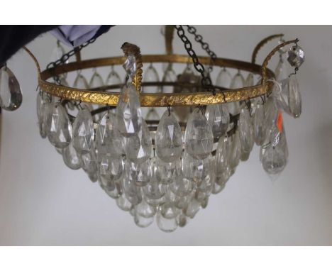 An early 20th century six-tier gilt metal ceiling light fitting, having glass teardrop shaped dropsCondition report: Width 36