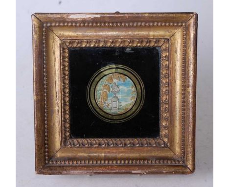 A small early 19th century woven silk panel, of circular form depicting an urn upon a plinth within landscape, in gilt frame,