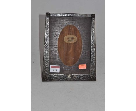 An Arts &amp; Crafts oak and hammered copper clad easel photograph frame, of slightly tapered rectangular form with embossed 
