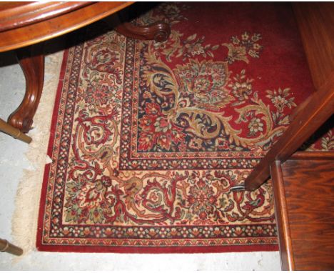 Large Kandahar design foliate carpet on a burgundy ground. CONDITION REPORT: Overall in used condition. Edges worn and some f