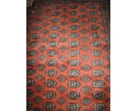 Middle Eastern design geometric carpet on a rust coloured ground with a series of guls. CONDITION REPORT: Dimensions: 98 x 62