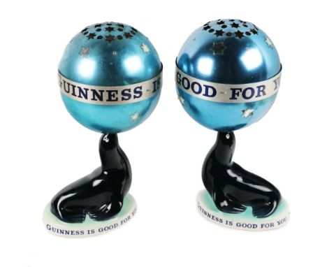 Advertisement: [Guinness &amp; Co.]&nbsp;Two rare Carltonware porcelain Lamps, modelled as Sea lions with global shaped pierc