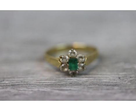 Emerald and white sapphire flower head 18ct yellow gold cluster ring, the central rectangular step cut emerald measuring appr