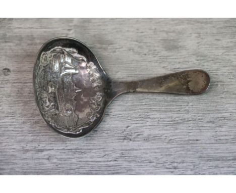 Early 20th century Dutch silver caddy spoon, the bowl with repousse floral border to cast countryside scene complete with sai