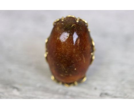 Copal amber 18ct yellow gold ring, the tumbled stone measuring approximately 3cm x 2cm, claw settings, pierced scroll mount, 