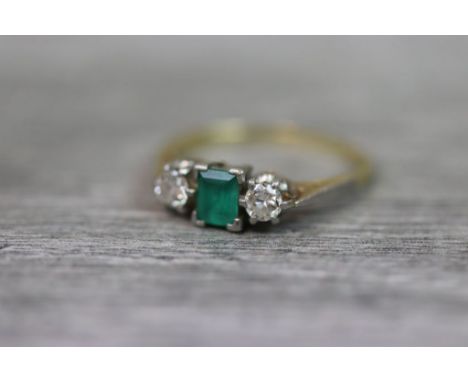 Emerald and diamond three stone 18ct yellow gold platinum set , the central rectangular cut emerald measuring approximately 4