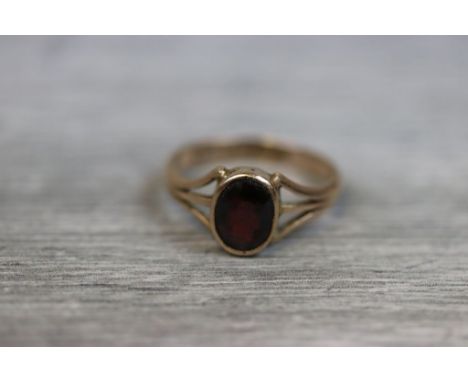 Early 20th century garnet 9ct yellow gold ring, the oval mixed cut garnet measuring approximately 8mm x 6mm, rub over setting