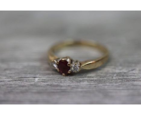 Ruby and diamond three stone 9ct yellow gold ring, the central oval mixed cut ruby measuring approximately 4.5mm x 4mm, flank