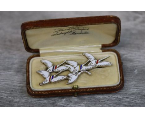 Erik Magnussen Danish enamelled silver gilt brooch modelled as a flock of flying white geese, with blue, red and yellow ename
