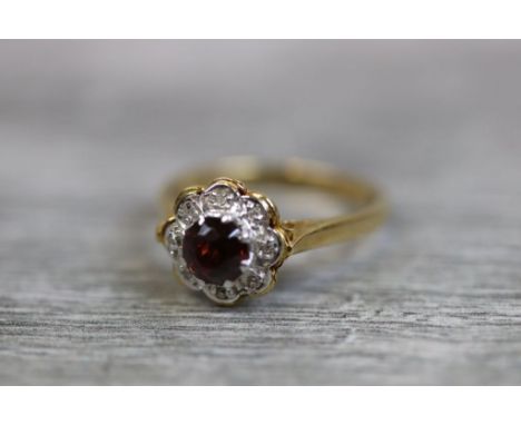 Garnet and diamond flower head 18ct yellow gold and white gold set ring, the central round mixed cut garnet diameter approxim