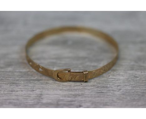 9ct yellow gold bangle with engraved foliate scroll decoration to full bangle, buckle clasp with pierced holes in bangle, hal