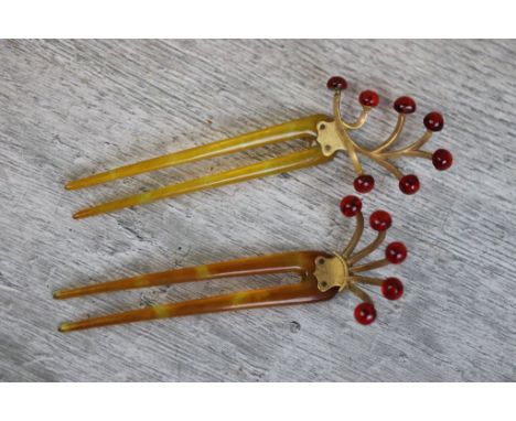 Two red amber type hair combs, each comb set with spherical amber stones to yellow metal sprigs, lengths approximately 10.5cm