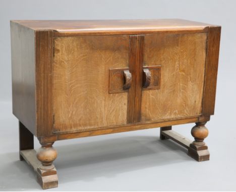 AN ART DECO OAK SIDEBOARD,&nbsp;fitted with a pair of doors flanked by reeded pilasters. 90.5cm high, 122cm wide, 50cm deep