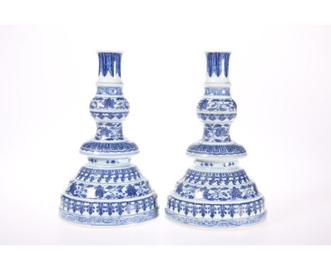 A PAIR OF CHINESE MING STYLE BLUE AND WHITE CANDLESTICKS, each decorated with concentric horizontal bands of lotus scroll alt