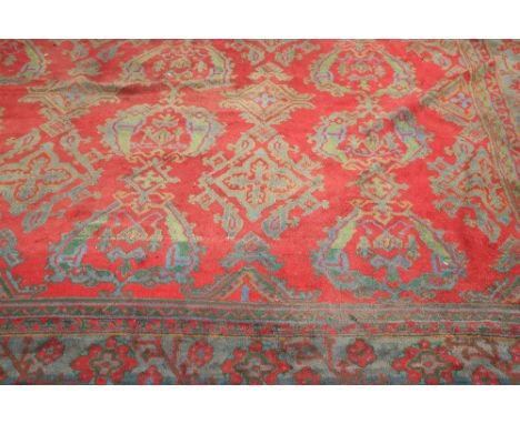 A VERY LARGE TURKISH OUSHAK CARPET, the red field with all-over green and blue pattern, enclosed within a blue border. 672cm 