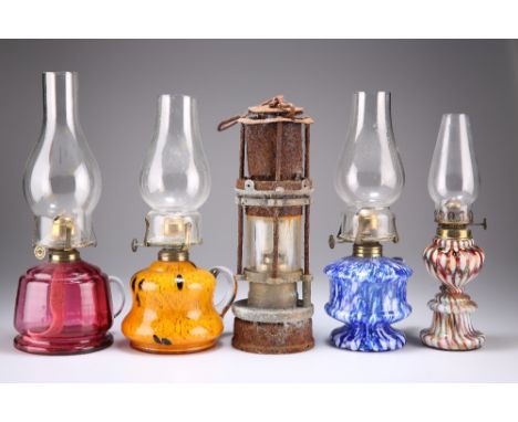 FOUR GLASS BASE OIL LAMPS, including two splatter glass examples (one a.f.), a cranberry glass example and a marble glass exa