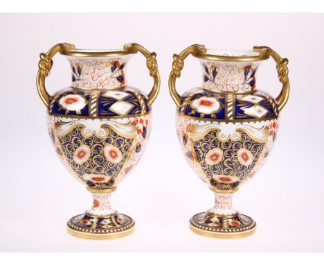 A PAIR OF LATE 19TH CENTURY DAVENPORT PORCELAIN TWIN HANDLED VASES, baluster form with knot handles and raised on circular ba