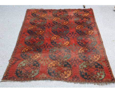 AN ANTIQUE ERSARI CARPET, c.1900,&nbsp;the brick red field with three columns of elephant foot guls, enclosed by a narrow bor