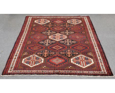 A PERSIAN BAKHTIARI CARPET, c.1960, the field with honeycomb design, enclosed within a triple border.&nbsp;299cm by 208cmThe 