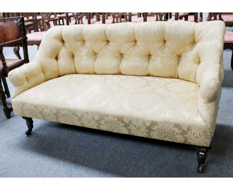 A Victorian Buttoned Sofa, with gold upholstery, on mahogany supports with large brass costors, 147cmMahogany legs, structura